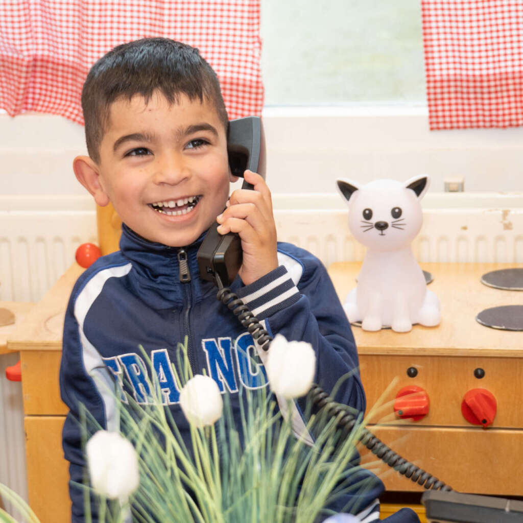Leerling met een telefoon aan het oor in de klas
